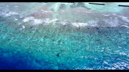 Luftbild über der Landschaft eines entspannenden Strandurlaubs an der Küste am blauen Meer mit weißem Sandhintergrund eines Picknicks