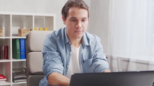Workplace of freelance worker at home office. Young man works using computer.
