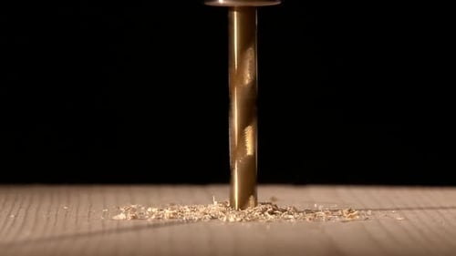 Continue Drilling with Sawdust on Wooden Plate Black