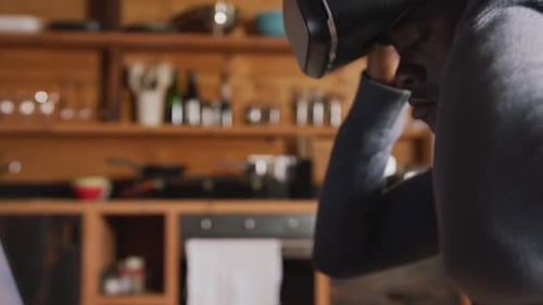 Young Man Using VR Headset in Home Kitchen