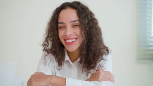 Smiling Woman with Curly Hair in White Shirt