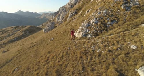 Lone Hiker Walks Grassy Mountain Trail