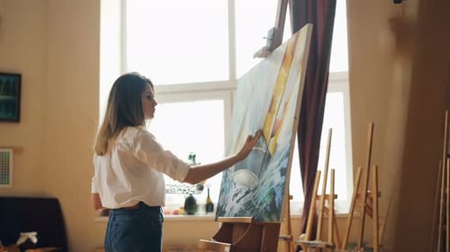 Female Artist Painting a Canvas in Bright Studio