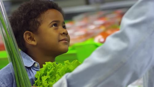 Boy Riding Shopping Cart at Supermarket