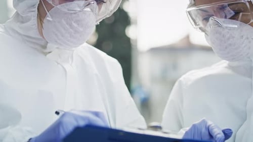Scientists in Protective Gear Working Together on Research