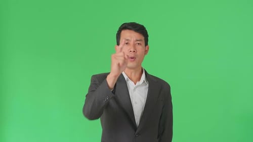 Asian Business Man Threatening With Finger In The Green Screen Studio
