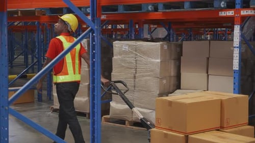 Young man pull and move cargo for transportation and distribution in the warehouse at factory.