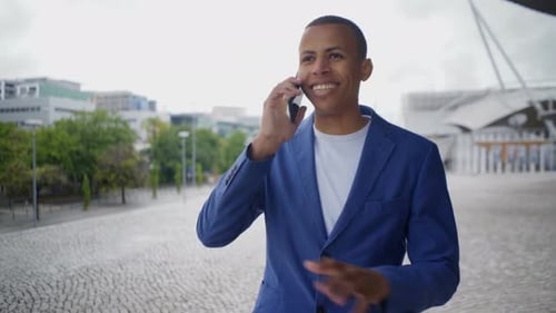 Young Adult in Blazer Talking on Phone in City