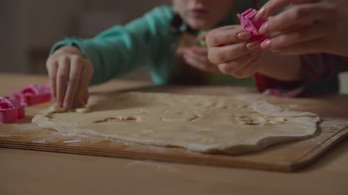 Child and Adult Making Cookies Together at Home