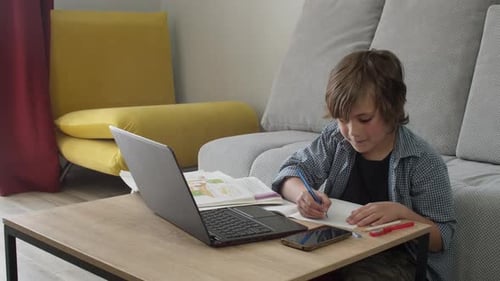 Boy Doing Schoolwork at Home with Laptop