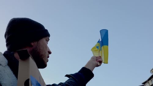 Young Adult Holding Flag at Urban Protest