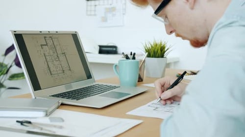 Slow Motion of Serious Young Specialist Drawing on Blueprint and Looking at Building Plan on