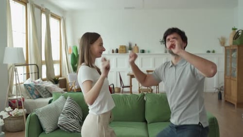 Happy Couple Dancing Together in Living Room