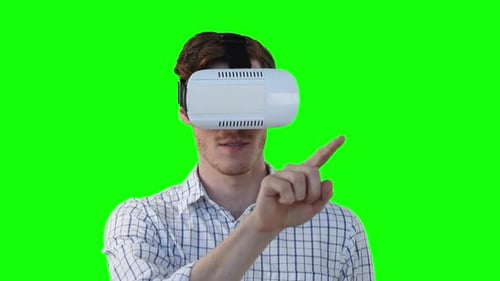 Caucasian man wearing a VR headset on green background