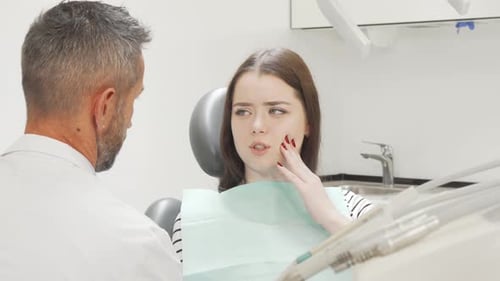 Young Woman Experiencing Toothache at Dentist's Office