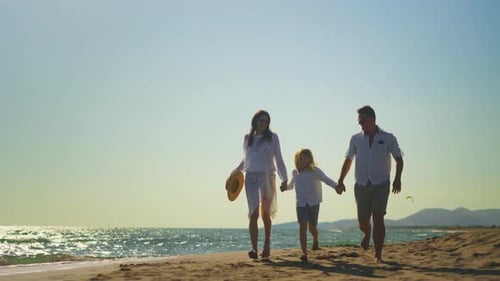 Parents with son running on beach