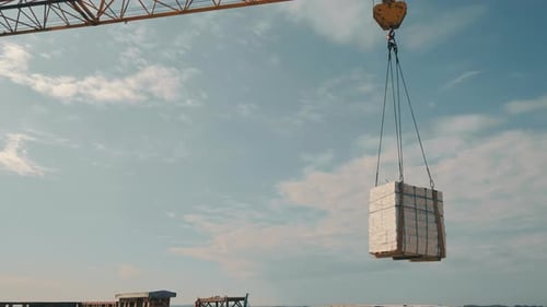 The Construction Crane Lifts the White Brick and Transfers It to the Construction Site