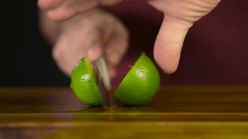 Cutting a Lime in Half on a Wooden Board
