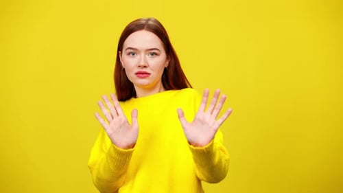 Woman with Red Hair Gestures No on Yellow Background