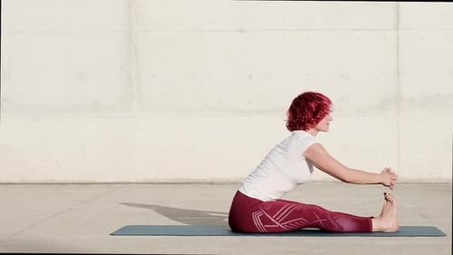 Anonymous woman stretching body in seated forward bend position