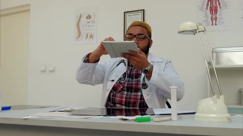 African American Male Doctor Taking Photo of Xray Results on His Tablet