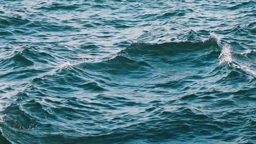 Flowing water surface. Close up of disturbed blue ocean water surface
