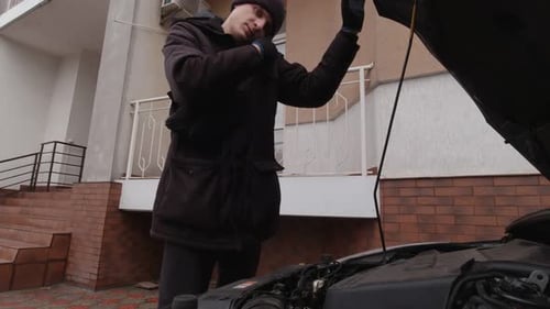 Mann überprüft das Öl im Auto in Zeitlupe