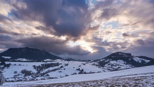 Flight Over a Forest Landscape with Snowy Meadows and the Valley Between the Wooded Hills