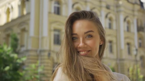 Portrait of Smiling Young Woman Sending Air Kiss Looking at Camera Smiling While Standing on
