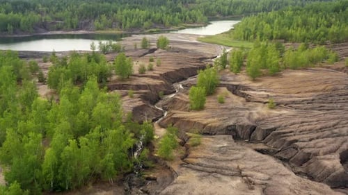 Aerial view of abandoned quarry with canyons and cracks.