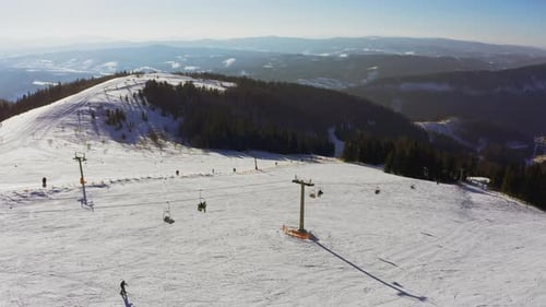 Ancienne station de ski sur une pente de montagne enneigée avec beaucoup de monde sur les skis et les snowboards