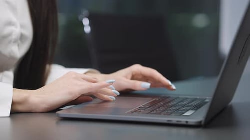 Female hands typing on laptop in office