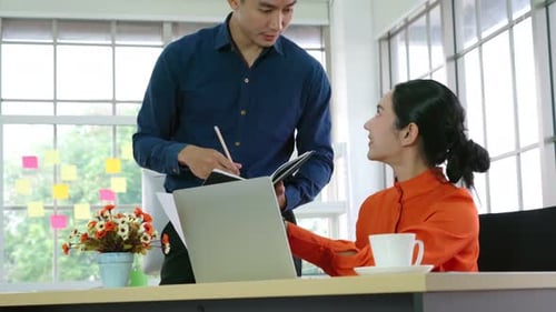 Two Business People Talk Project Strategy at Office