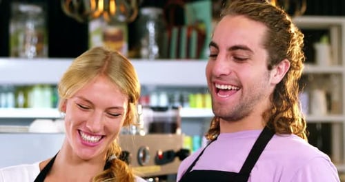 Waiter and waitress smiling at counter