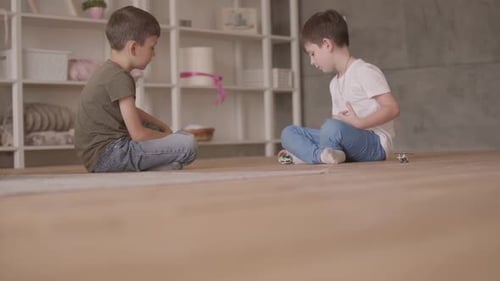 Two Young Children Playing Together on Floor Indoors