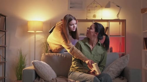 Woman Reads as Teen Shows Laptop