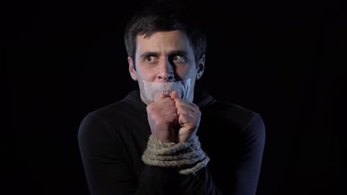 Un homme otage effrayé aux mains liées