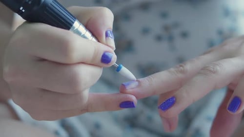 Manicurist Removes Purple Nail Polish on Her Hands