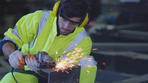 Man Grinding Metal with Sparks Flying in Factory