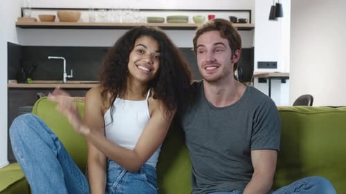 Happy Young Couple Chatting on Sofa at Home