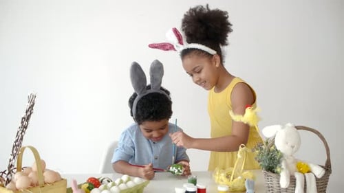 African American Kids in Funny Bunny Ears Colouring Eggs on Easter