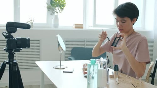 Maquilladora profesional graba Vídeo para un vlog de Internet aplicando cosméticos en casa