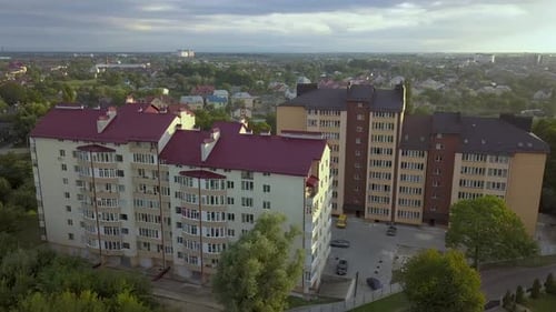 Aerial view of multistory apartment building in green residential area.