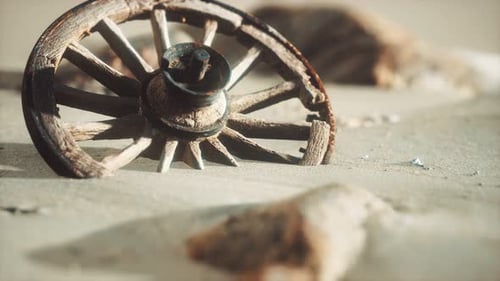 Old Wooden Wagon Wheel Partially Buried in Desert Sand