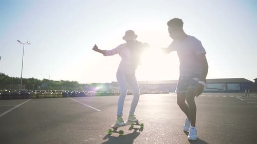 Young Attractive Mixed Race Couple Riding Skateboards and Having Fun Slow Motion