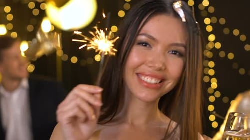 Linda senhora asiática segurando a luz de Bengala e dançando na festa de ano novo, relaxamento