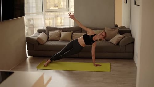 Athletic Woman Practicing Yoga in Apartment Living Room