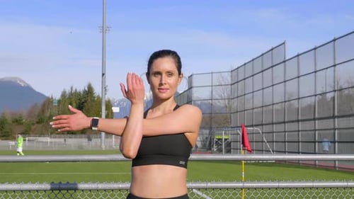 Woman Stretching Outdoors on Sunny Day