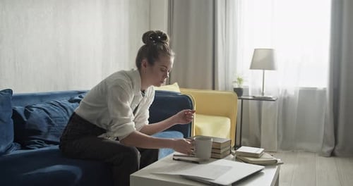 Woman Working at Home on Couch