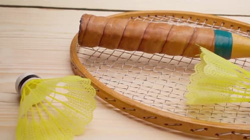 Badmintonschläger und Federball auf Holzuntergrund, Nahaufnahme
